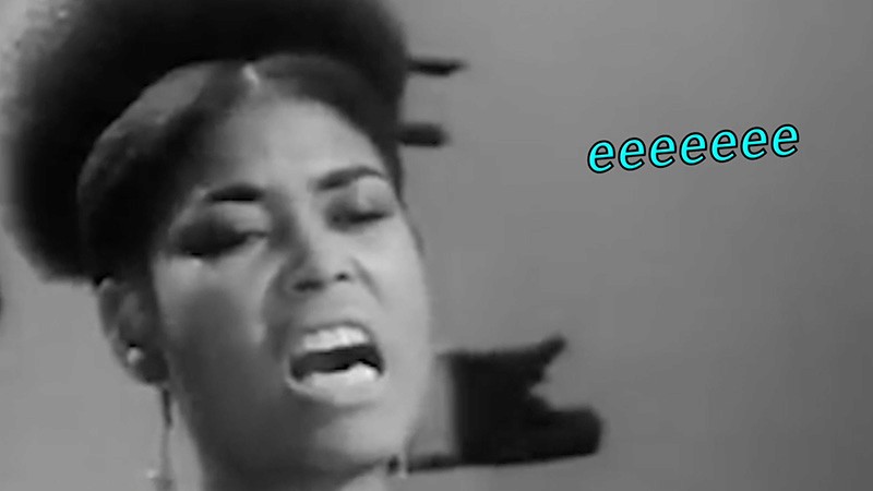 Film still: black-and-white archive close-up of a woman singing, with glowing turquoise caption reading eeeeeee