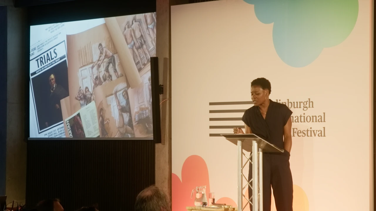 Adura Onashile speaks at a lectern beside projected archive imagery at Edinburgh International Book Festival
