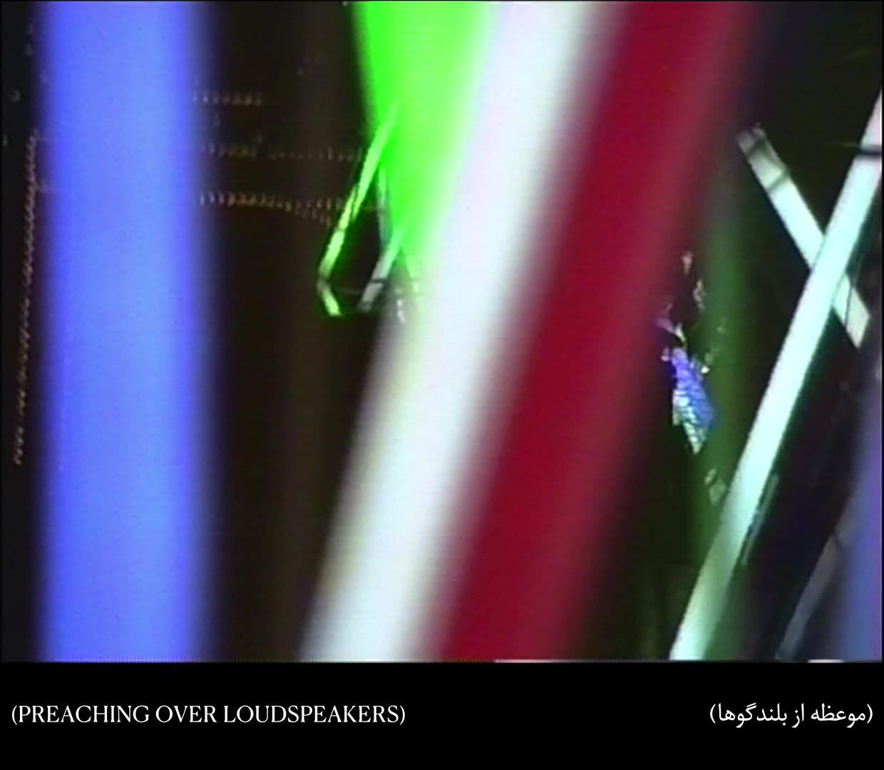 Hi8 footage still: blurred vertical streaks of coloured light, subtitled "(Preaching over loudspeakers)"