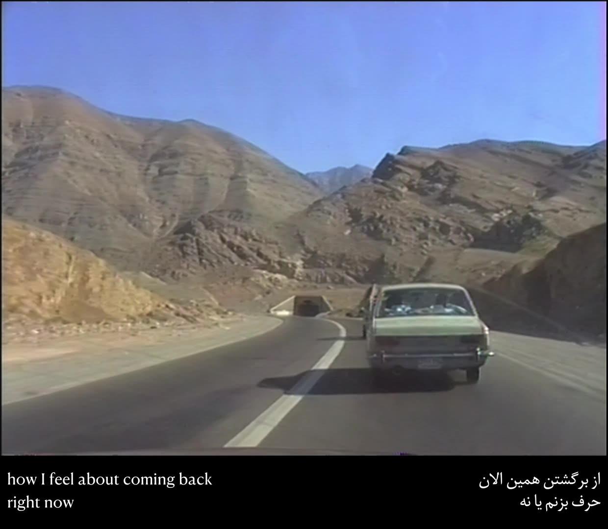 Hi8 footage still: a car on a desert mountain road in Iran, subtitled "how I feel about coming back right now"
