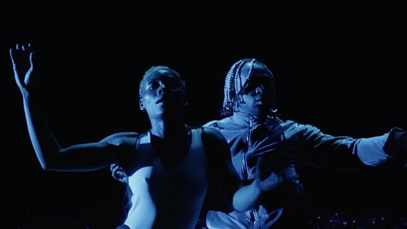 Film still from Grin: two dancers moving together in deep blue light