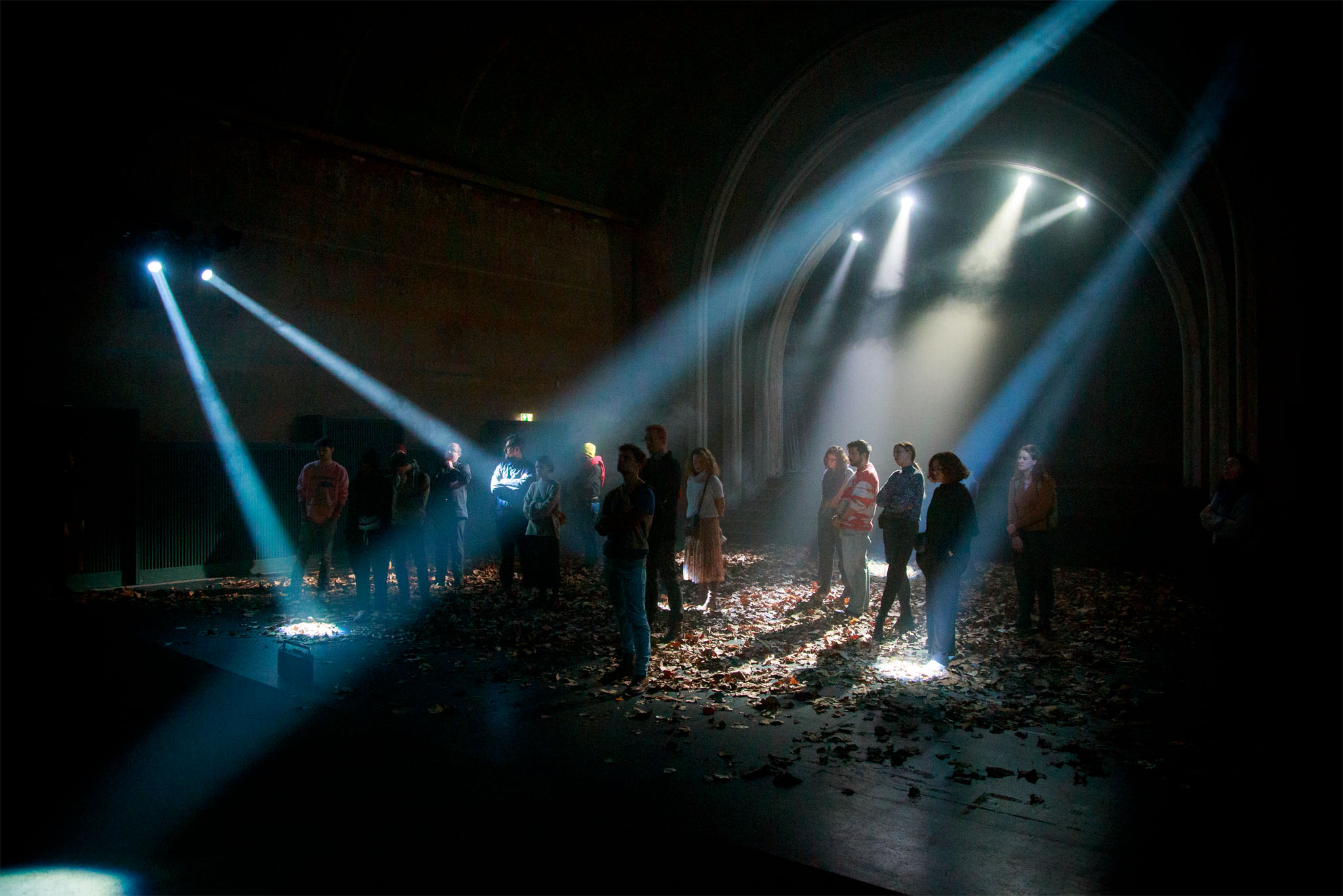 Criss-crossing beams of Iana Boitcova's lighting sweep over the audience standing among scattered leaves